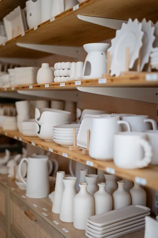 Étagères de bols, mugs et vases blancs à choisir au café